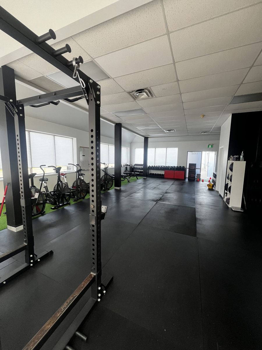 Squat rack with pull-up bar on the TCT Gym training floor.